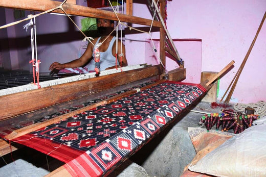 a man sitting near a handloom in andhra pradesh, india. weaving a 300 year old textile called telia rumal. acid moons uses that textile to make our shirts