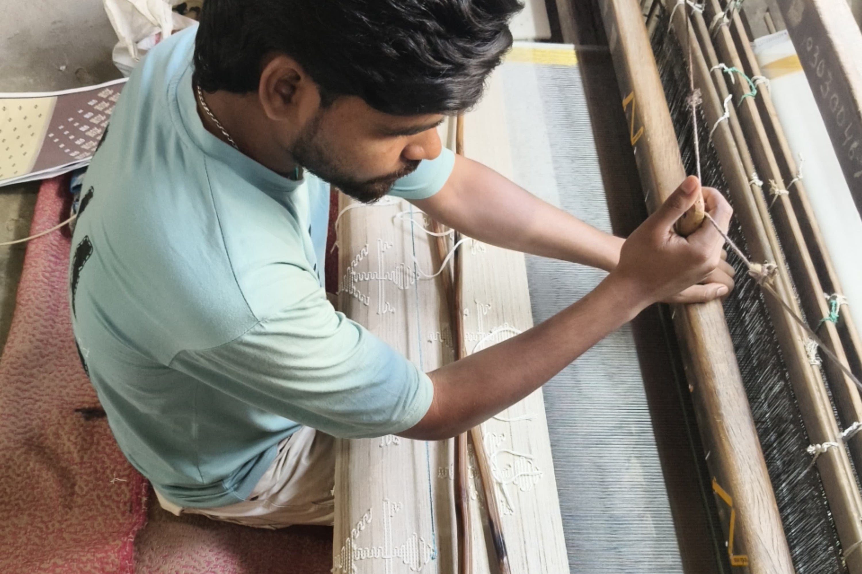 Person working with a loom in a textile workshop in Bihar for Acid Moons